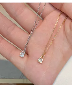 Detailed view of silver and 14K gold plated lock pendant necklaces with cubic zirconia