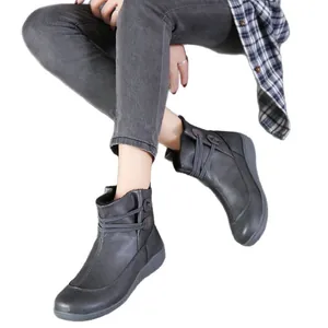 Klassische dunkelgraue Martin Boots im Vintage-Stil für Damen am Modell vor weißem Hintergrund