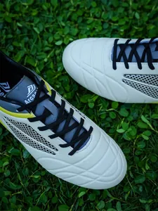 Close-up detail of white professional soccer shoes with leather texture and black laces