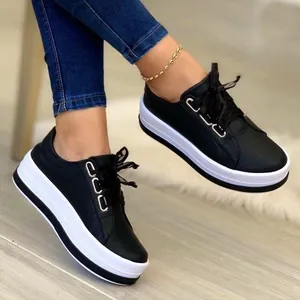 Side view detail of stylish women's black platform sneakers with white soles and laces