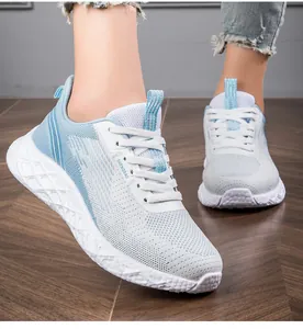 Close-up detail of women's breathable blue and white fly-knit mesh running sneakers