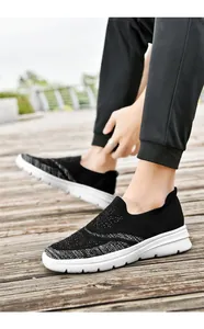 Vista dettagliata di scarpe da camminata in maglia nera traspirante su pedana in legno