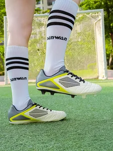 Close-up detail of professional soccer shoes with long spikes on a green grass field