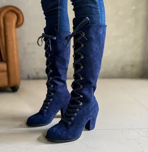 Close-up detail of blue suede knee-high lace-up boots featuring a sturdy chunky heel