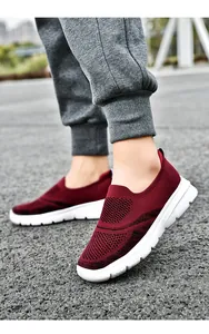 Primo piano di scarpe da camminata in rete Fly-Knit rosse traspiranti indossate fuori