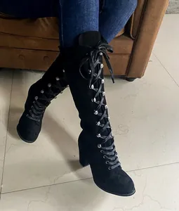 Detail of black suede lace-up long boots with chunky heel and round toe design