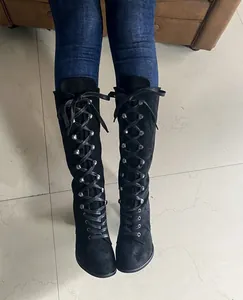 Detail view of black suede lace-up boots with round toe and chunky heel for women.