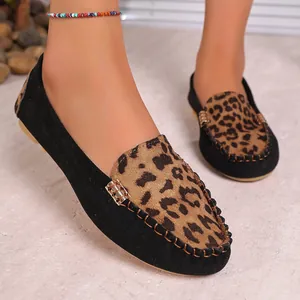 Close-up of leopard print detail and black suede on women's flat loafers.