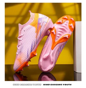 Gedetailleerd overzicht van roze en oranje voetbalschoenen met FG-noppen voor training
