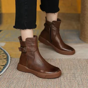 Close-up of vintage brown leather ankle boots with side buckle and zipper detail