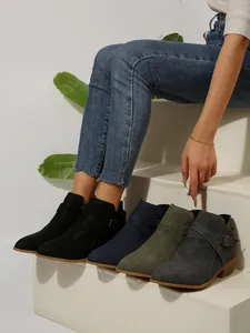 Detailed view of stylish pointed toe Chelsea boots with cross straps in diverse colors