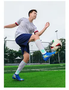 Dynamische actiefoto van professionele blauwe voetbalschoenen op een kunstgras voetbalveld
