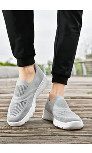 Dettaglio delle scarpe da camminata grigie traspiranti in fly-knit su legno