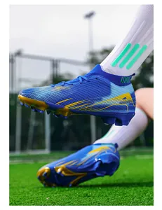 Detailopname van blauwe hoge voetbalschoenen met gebreide kraag op een grasveld