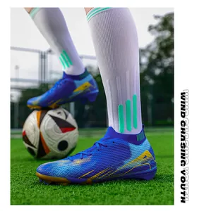 Professionele blauwe gebreide voetbalschoenen op het veld met bal.
