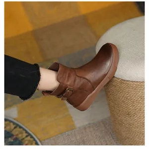 Close-up detail of brown vintage leather flat ankle boots with stylish side buckle