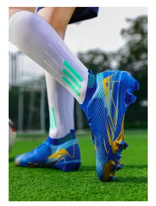 Detailopname van blauw-gele flyknit voetbalschoenen op kunstgrasveld