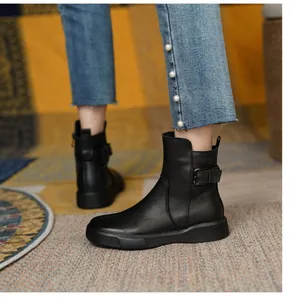 Close-up of stylish black flat ankle boots featuring side buckle and non-slip rubber sole