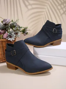 Detailed side view of navy blue pointed-toe Chelsea boots featuring cross straps and buckles