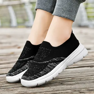 Sneakers slip-on in maglia nera traspirante con suola bianca per camminata outdoor.