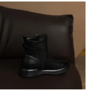 Side view of comfortable black leather flat ankle boots with practical side zipper