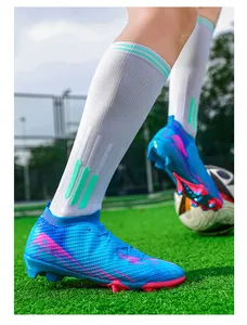 Detailopname van professionele blauwe en roze flyknit voetbalschoenen op een grasveld