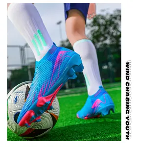 Detail van blauwe en roze flyknit voetbalschoenen met FG-noppen op het grasveld