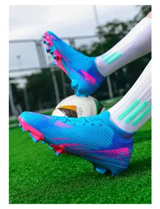 Gedetailleerde opname van blauwe flyknit voetbalschoenen met roze accenten op het veld