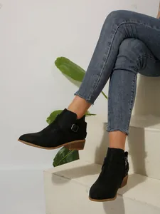 Women's black pointed-toe ankle boots with square heel and side zipper detail on model