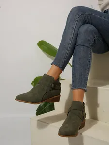 Close-up of olive green pointed toe ankle boots with side buckle and block heel