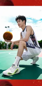 Close-up of white and lime green professional basketball shoes worn by a model on court