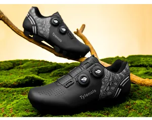 Macro view of black professional cycling shoes featuring dual rotary knobs on mossy background