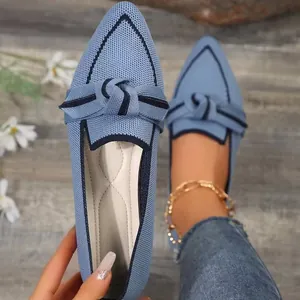 Close-up of light blue flyknit pointed toe flats with a decorative bow-knot detail