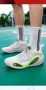 Detail view of low-top white basketball training shoes with lime green accents on court