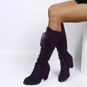 Detailed side view of dark purple suede knee-high lace-up boots with chunky heels