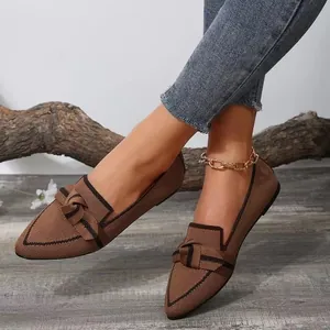 Detailed view of coffee brown pointed-toe knit flat shoes with decorative bow accent
