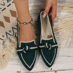 Gros plan sur les mocassins en tricot vert foncé à bout pointu avec nœud et bord blanc