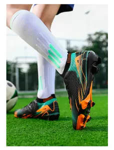 Detail van professionele flyknit voetbalschoenen met noppen op een groen voetbalveld.