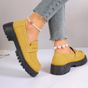 Detail of yellow platform loafers with chunky soles and a British retro design