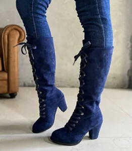 Stylish navy blue suede lace-up knee-high boots with chunky high heel worn by a model