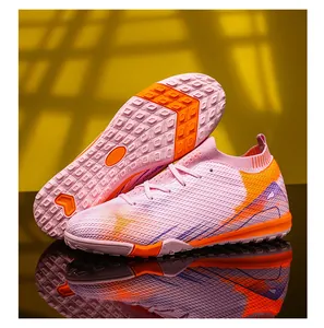 Gedetailleerd overzicht van roze fly-knit voetbalschoenen met oranje noppen voor trainingen