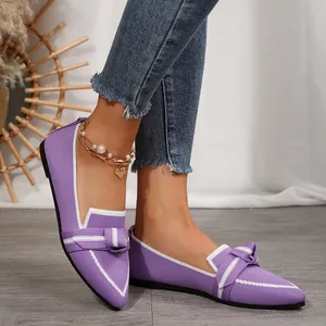 Gros plan détaillé de ballerines violettes à bout pointu avec nœud et maille fine.