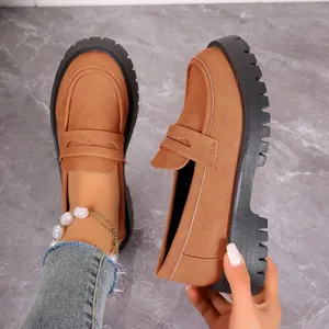 Close-up of stylish brown suede loafers featuring thick black lug soles and slip-on design