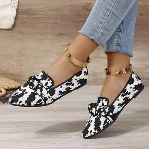 Gros plan sur des ballerines à bout pointu avec motif noir et blanc et détail de nœud élégant