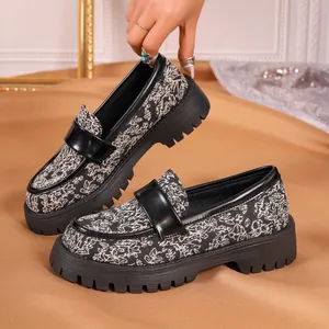 Close-up of vintage floral loafers with chunky lug sole and black patent detail.