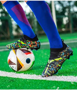 Close-up of colorful patterned men's soccer cleats with FG studs on turf field