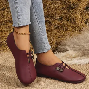 Primer plano de zapatos planos de cuero suave burdeos con botones decorativos