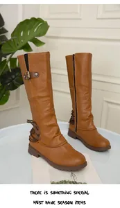 Close-up detail of tan equestrian tall boots with square heel, side zipper and buckle