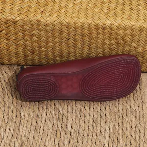 Detalle de la suela de goma antideslizante de un zapato plano de cuero suave color granate