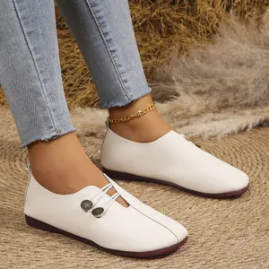 Detalle del cuero texturizzato blanco y los botones decorativos de estos mocasines.